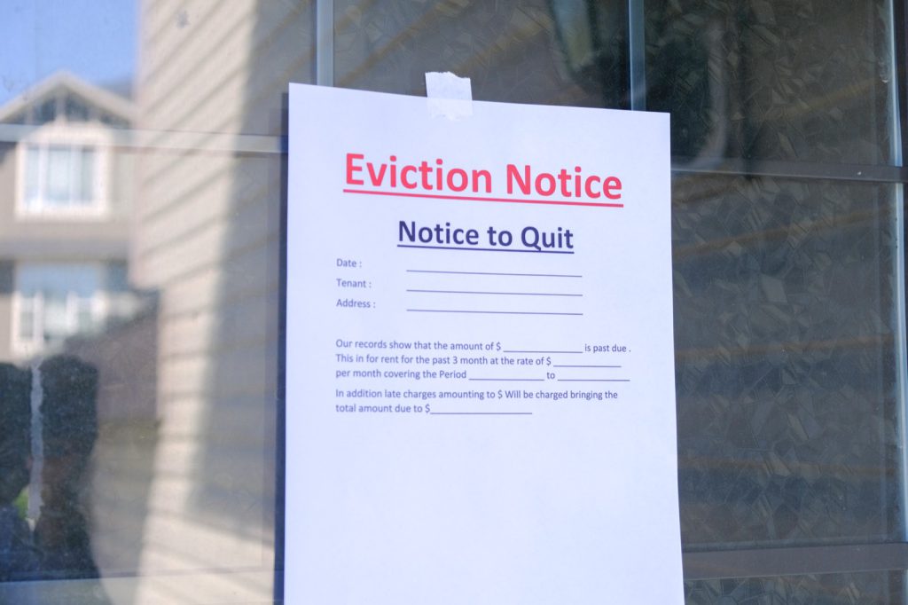 A printed eviction notice taped to a tenant's front door, the first step a California landlord must take before filing an unlawful detainer lawsuit.