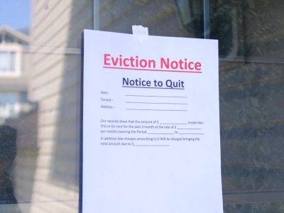 A printed eviction notice taped to a tenant's front door, the first step a California landlord must take before filing an unlawful detainer lawsuit.