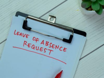 A leave of absence request form on a wooden table, representing CFRA and FMLA medical leave and reasonable accommodation requests in California.