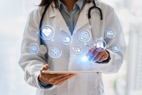A doctor in a white coat uses a tablet with holographic medical icons floating above it, representing health and medical services. Amidst the icons like the heart and DNA, new developments emerge in mold litigation, highlighting advances in healthcare technology.